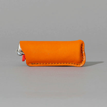 Lighter in Orange Latigo, angled view lying flat, shot 2