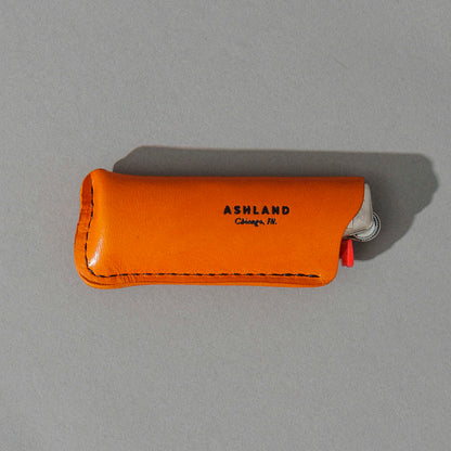 Lighter in Orange Latigo, angled view lying flat, shot 3