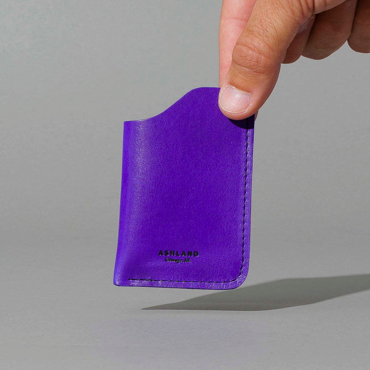 One-Shot Card Case in Violet Latigo, held in hand, shot 1