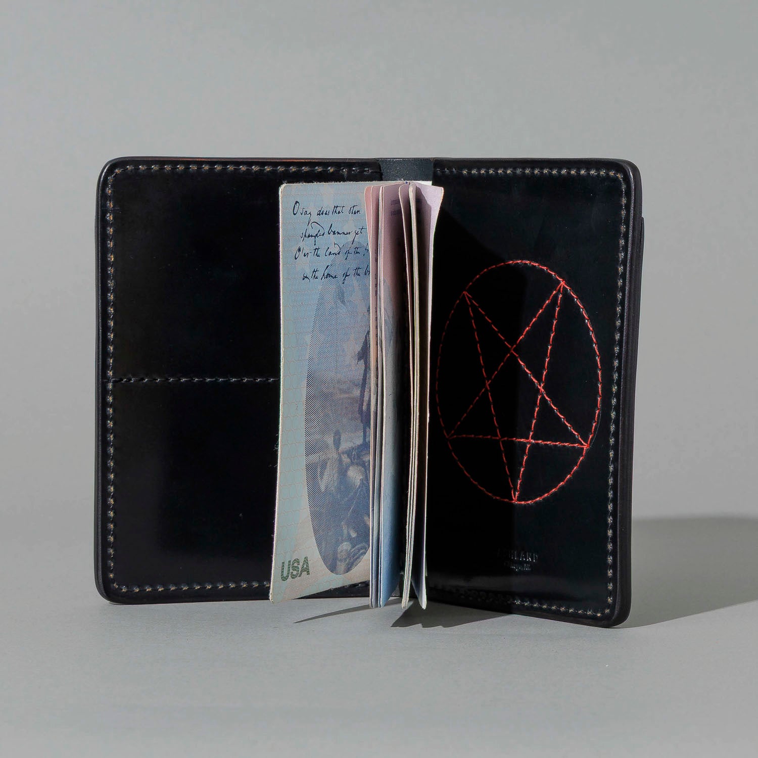 One-Off Traveler Passport Holder in Black Shell Cordovan with Red Pentagram Embroidery, open with cash and cards