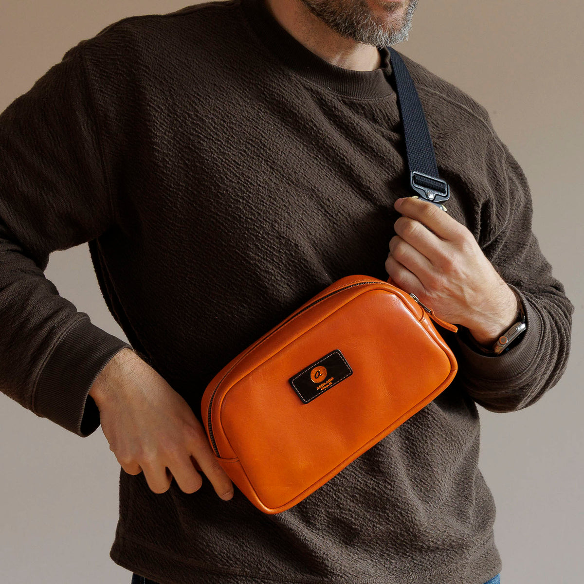One-Off Sling Bag in Orange Latigo, worn crossbody by a model, shot 1