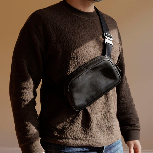 Sling Bag in Black Aspen Horsehide, worn crossbody by a model, shot 1