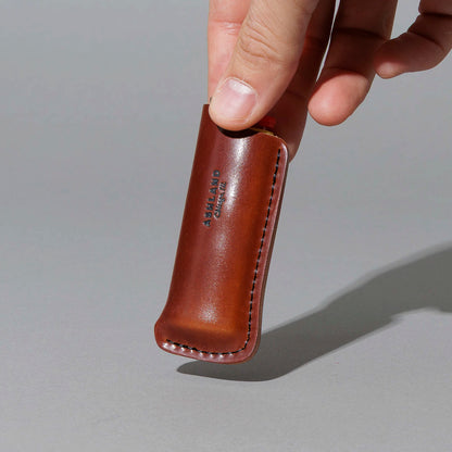 One-Off Lighter in Blood Orange Shell Cordovan, BIC lighter in sheath, held in hand, shot 1