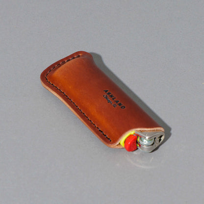 One-Off Lighter in Blood Orange Shell Cordovan, angled view lying flat