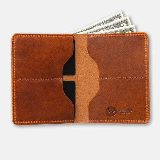 A brown, bi-fold leather wallet with card slots and some cash protruding from the bill slot, placed on a flat surface.