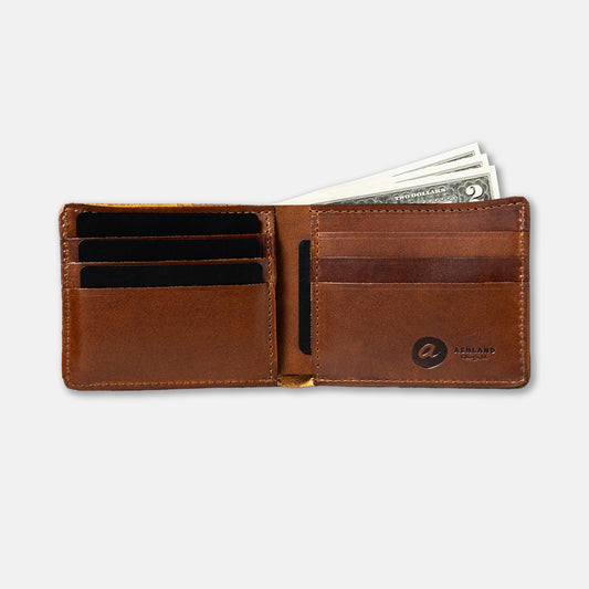 A brown Johnny the Fox bifold wallet made of Horween leather, open to show multiple card slots and a few dollar bills.
