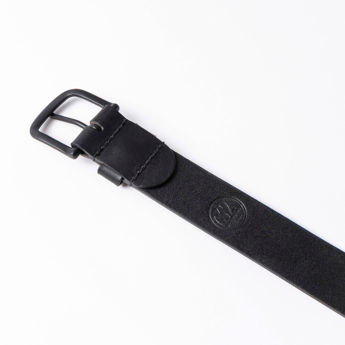 Black leather belt with a black buckle on a white background, reverse side of leather showing grain and size stamp