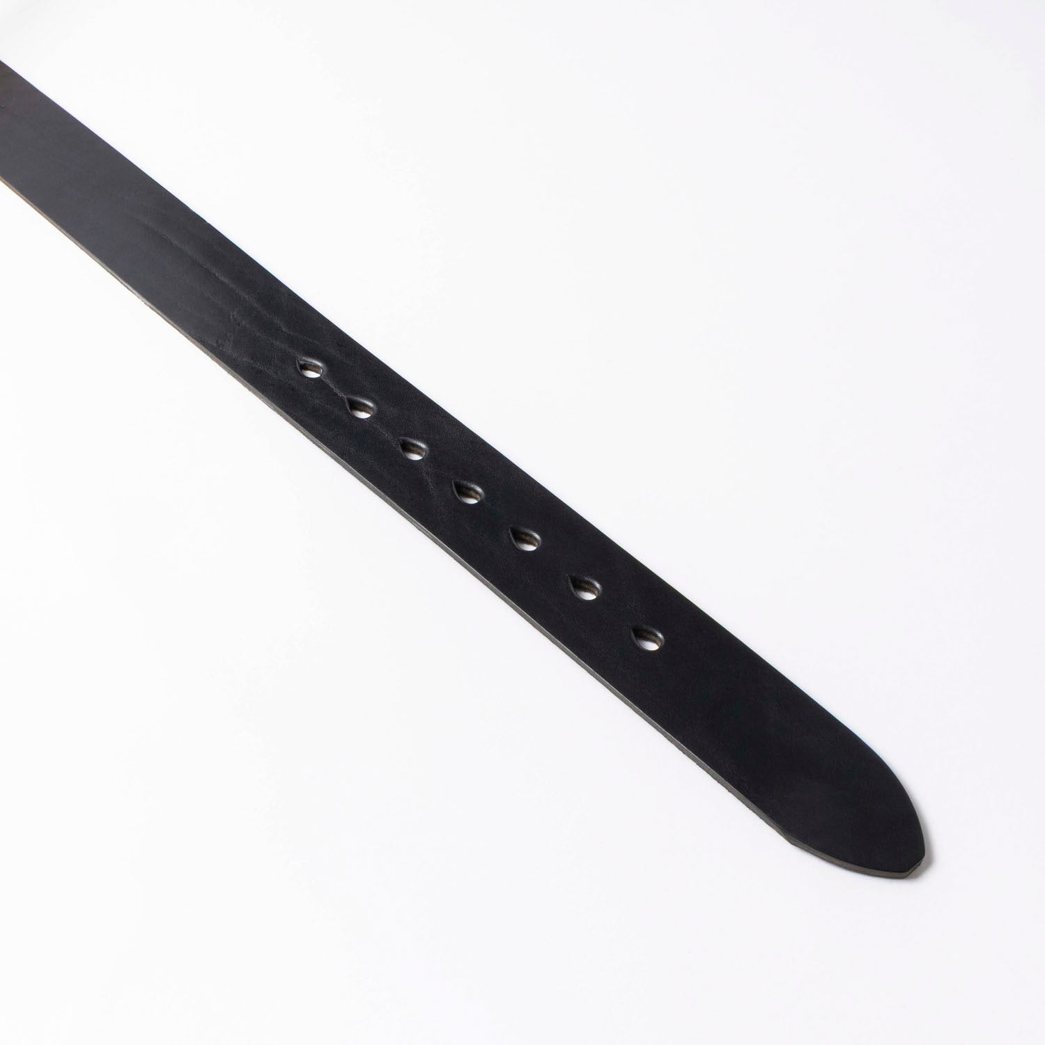 Belt end showing black leather grain and tear-drop belt holes