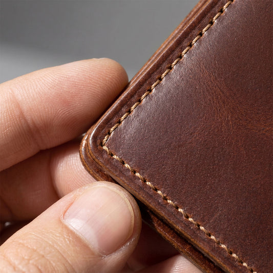 Close-up of the corner of the Fat Herbie wallet in brown Horween® Cypress held in a hand, showing stitching and edge