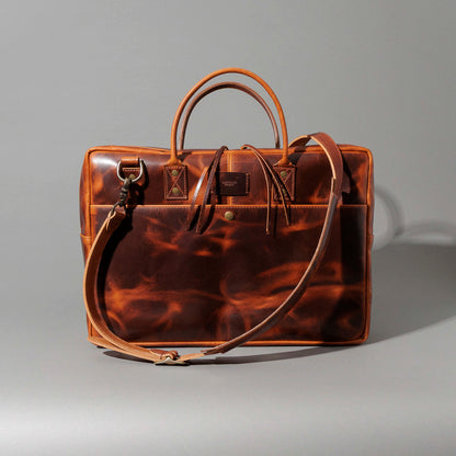 Close-up of the Ashland Leather LaSalle Briefcase's strap and hook resting on a luggage handle