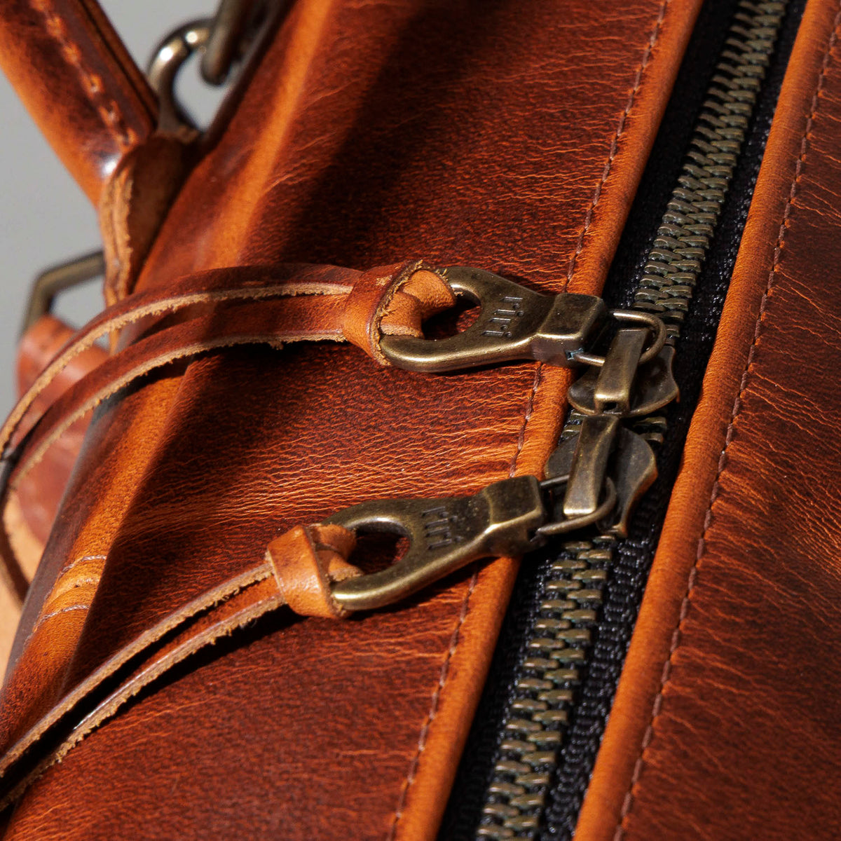 Close-up of the zipper pull and handle-wrap stitching on the Ashland Leather LaSalle Briefcase