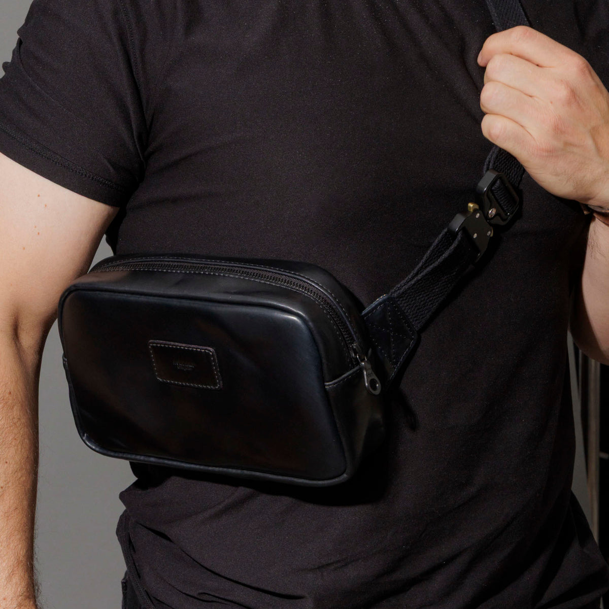 Retrieving keys from the exterior back pocket of the Ashland Leather Sling Bag
