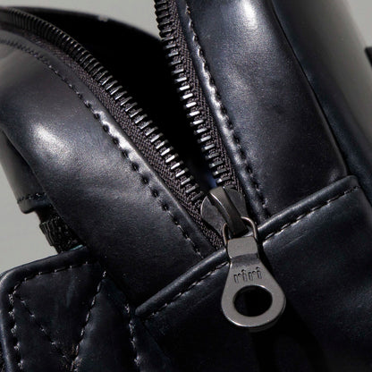 Ashland Leather black Shell Cordovan Sling Bag, low angle back view on gray background