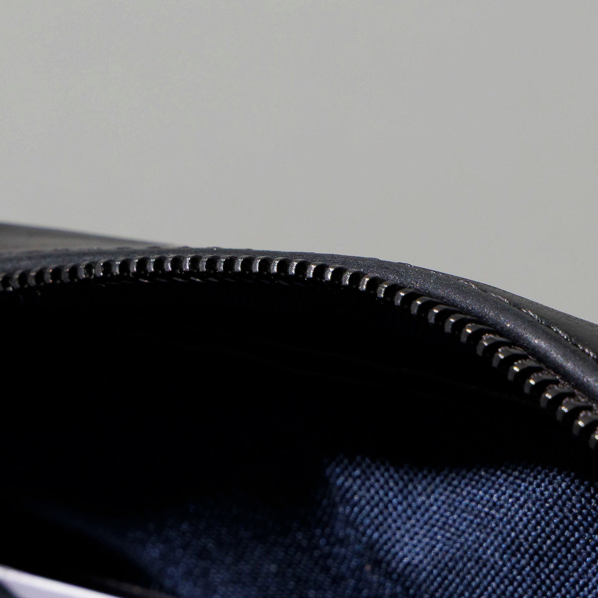 Close-up of the exterior back zip pocket and strap on the Ashland Leather Sling Bag