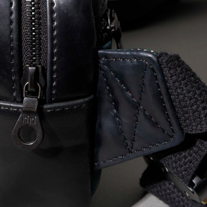 Close-up of the Ashland Leather brand plaque on the Sling Bag's front panel