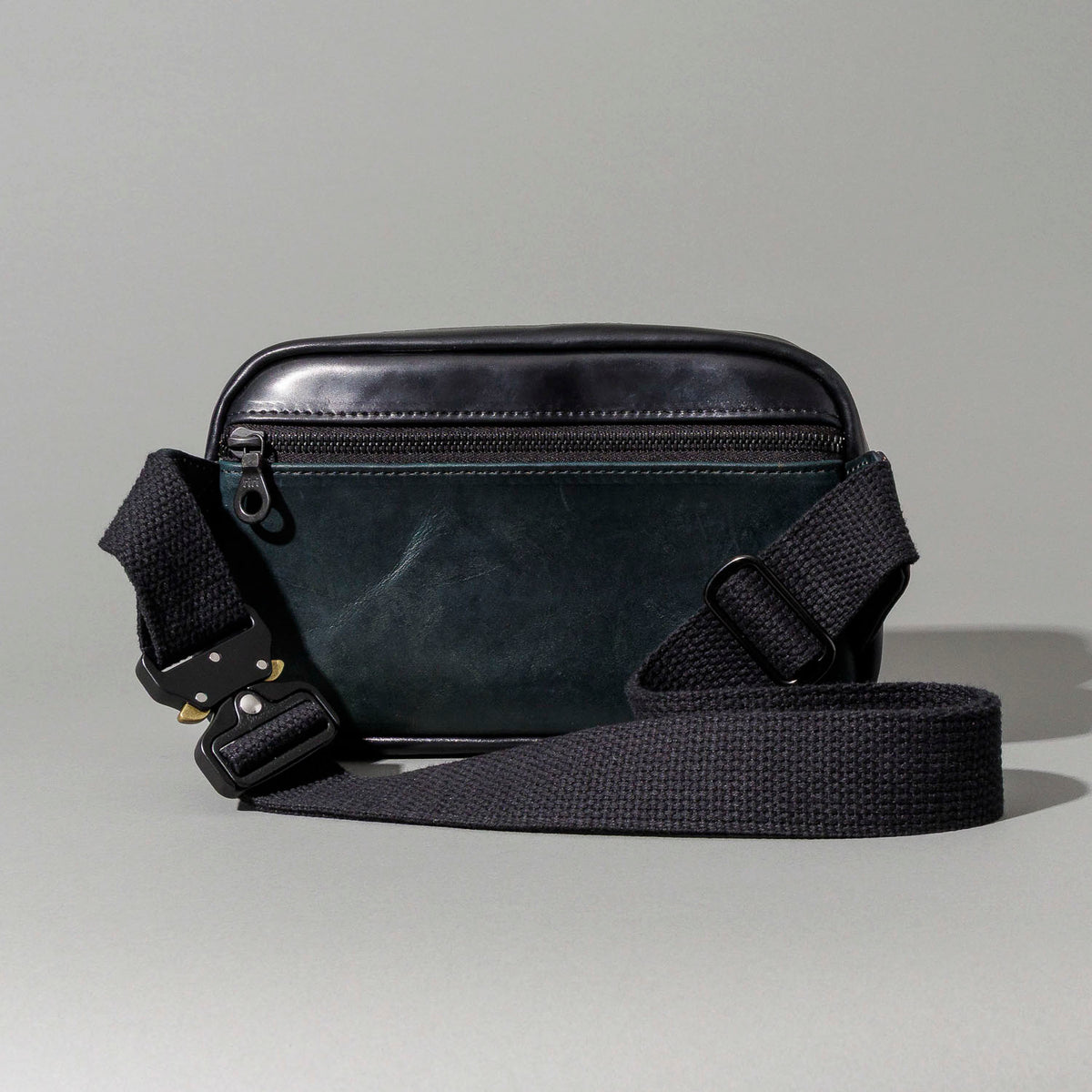 Ashland Leather black Shell Cordovan Sling Bag, front three-quarter view with strap draped to the side