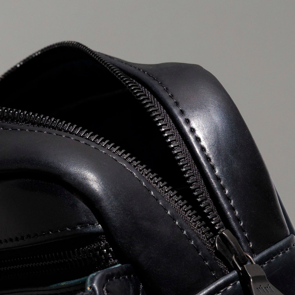 Close-up of the top handle and strap hardware clip on the Ashland Leather Sling Bag