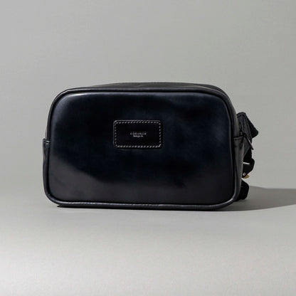Hand opening the Ashland Leather Sling Bag to show the interior pocket organization