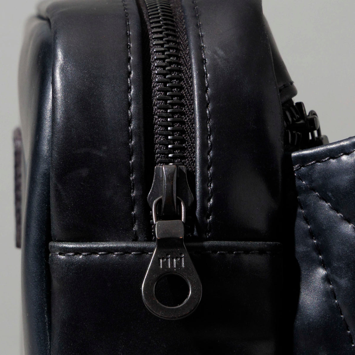 Ashland Leather black Shell Cordovan Sling Bag, side-back three-quarter view with strap wrapped
