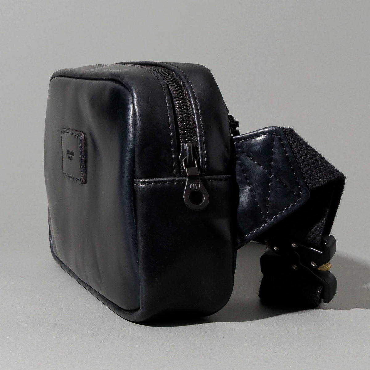 Close-up of the adjustable webbing strap and hardware on the Ashland Leather Sling Bag