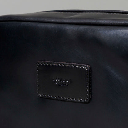 Close-up of the front zipper pull and edge stitching on the Ashland Leather Sling Bag