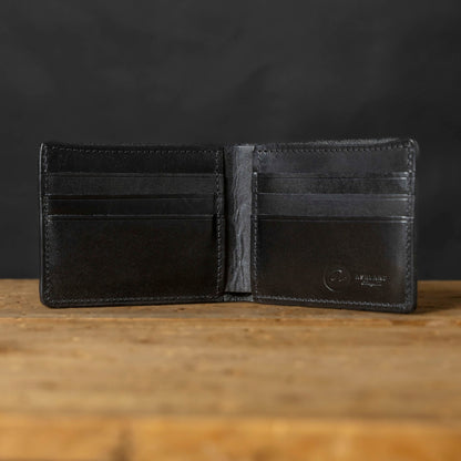 Black leather wallet open on a wooden surface with a dark background