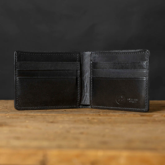 Black leather wallet open on a wooden surface with a dark background