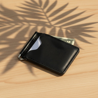 Black leather money clip with a dollar bill on a light gray background