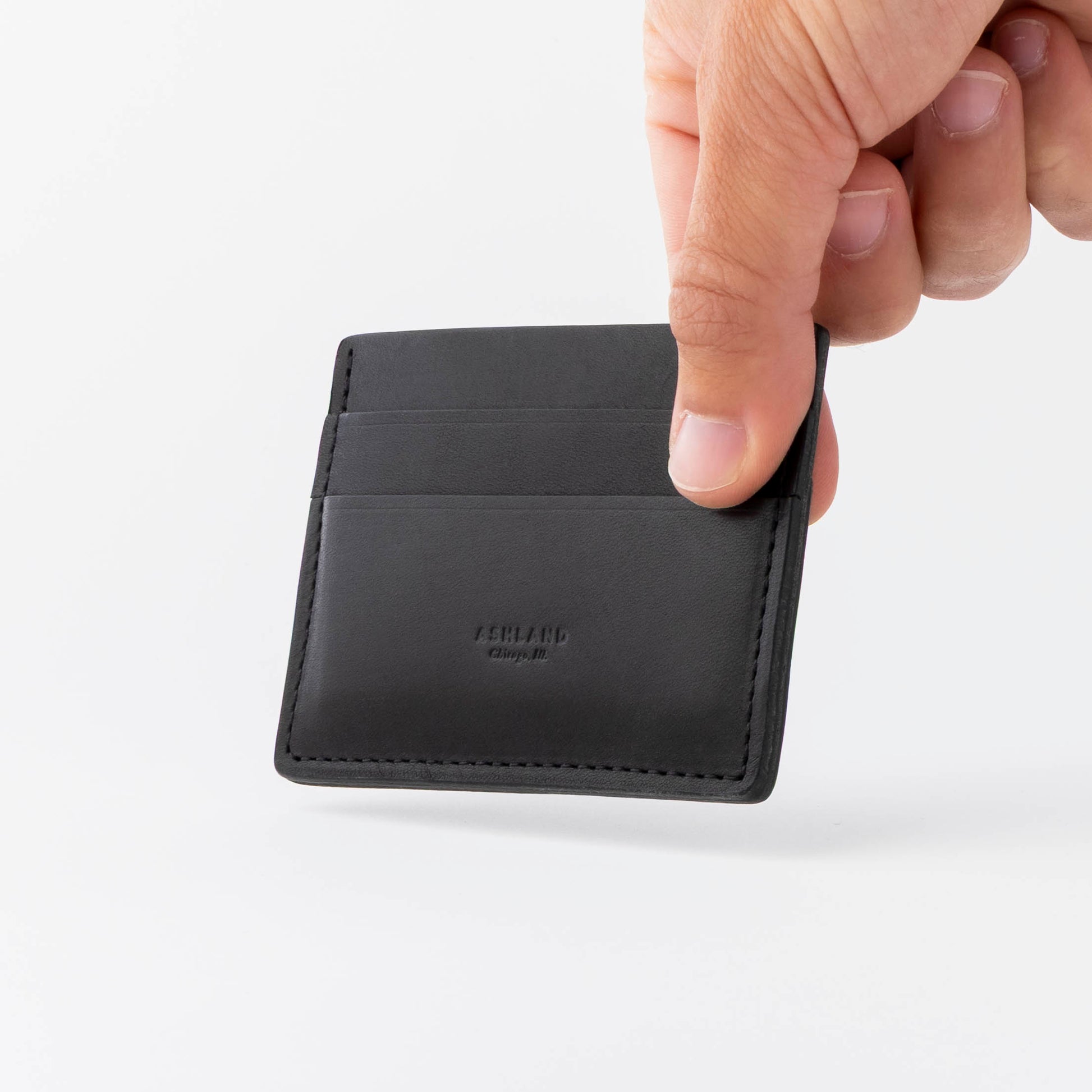 Hand holding a black leather wallet against a white background