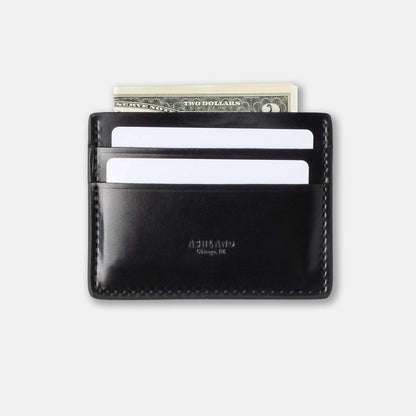 Black leather wallet with money and cards on a light gray background