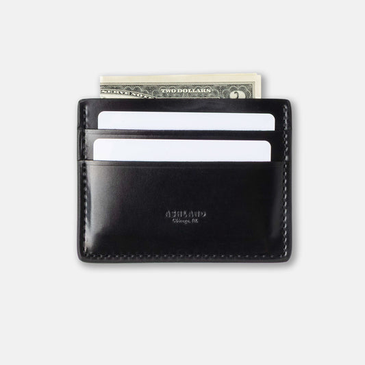 Black leather wallet with money and cards on a light gray background