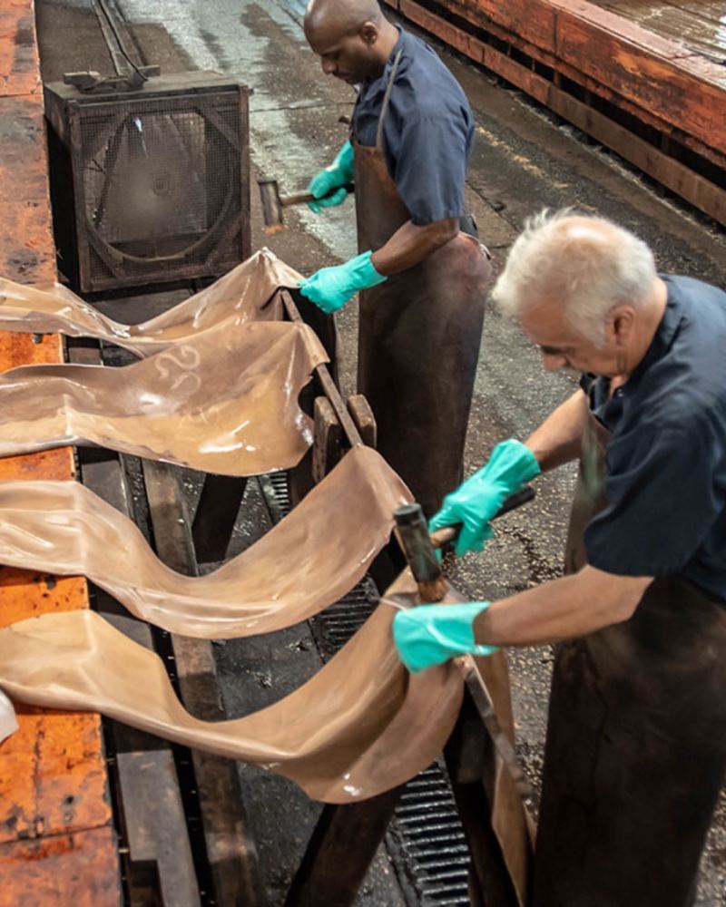 Workers pulling hides over a rack at the Horween® tannery, Chicago