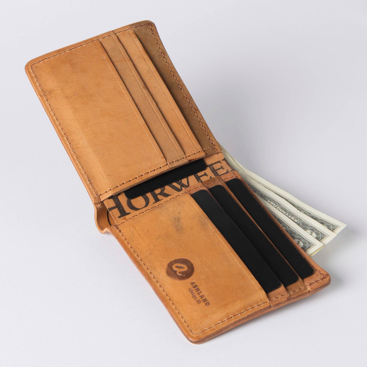 Brown leather wallet with money on a light gray background