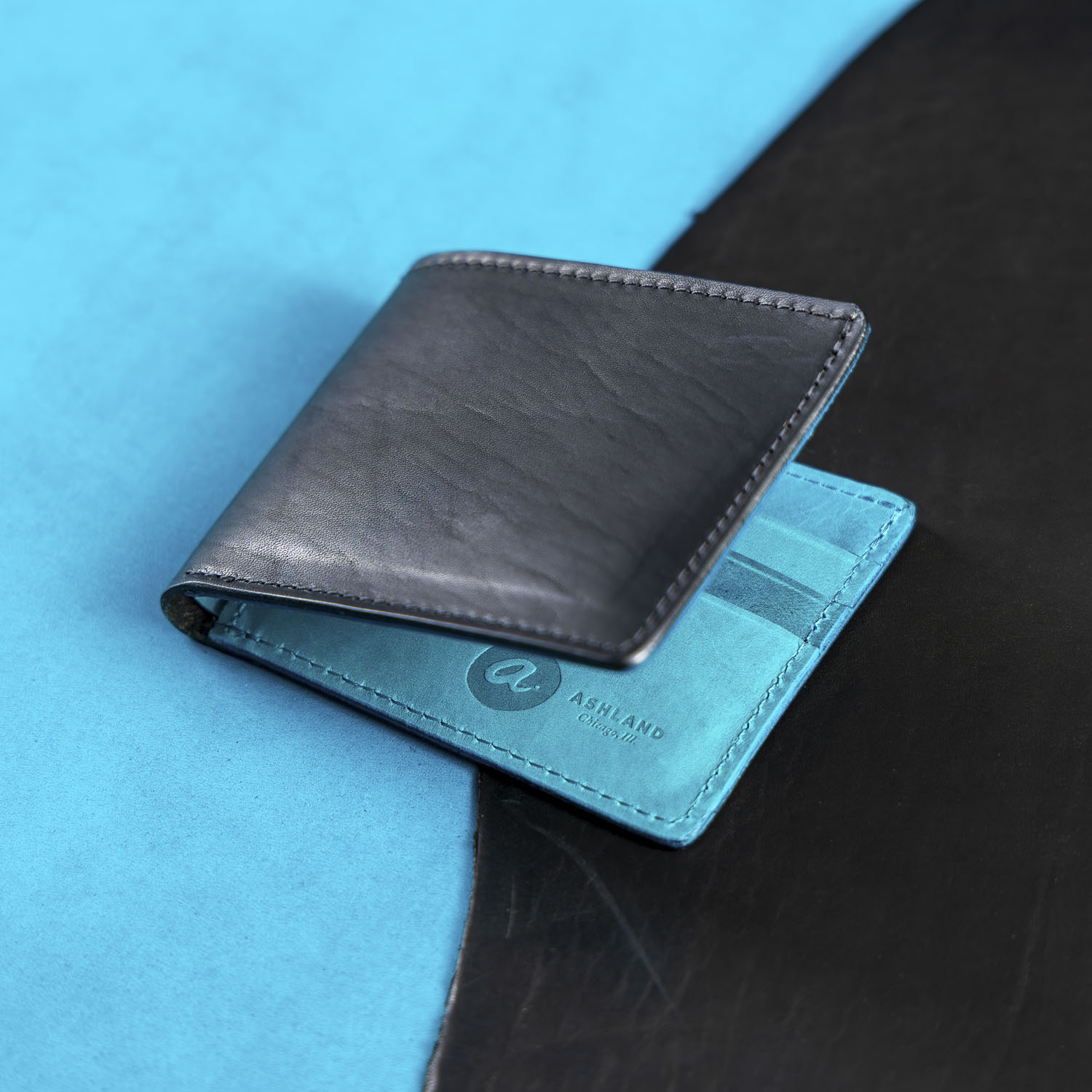 black and blue johnny the fox wallet on a textured surface with a brand logo.