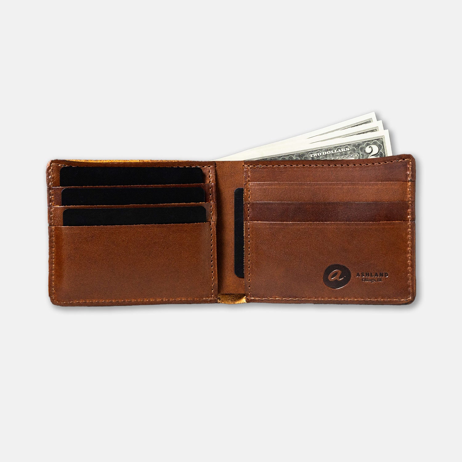 A brown Johnny the Fox bifold wallet made of Horween leather, open to show multiple card slots and a few dollar bills.