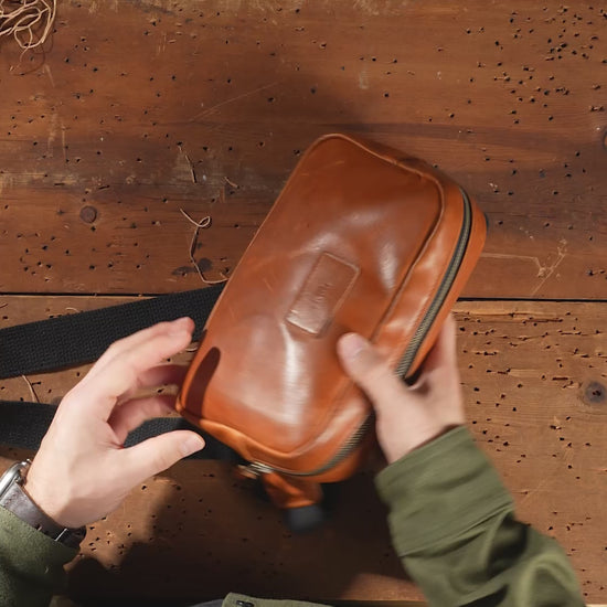 Leather sling bag in Horween® English Tan Dublin, video showing everyday items loaded into the interior one at a time to show capacity