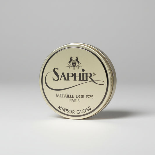 Saphir Mirror Gloss tin on a gray background