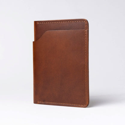 Brown leather passport holder on a light gray background