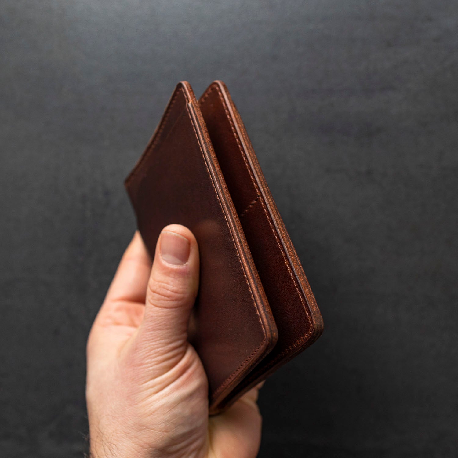 Hand showing edge workmanship of Cypress Fat Herbie men's wallet