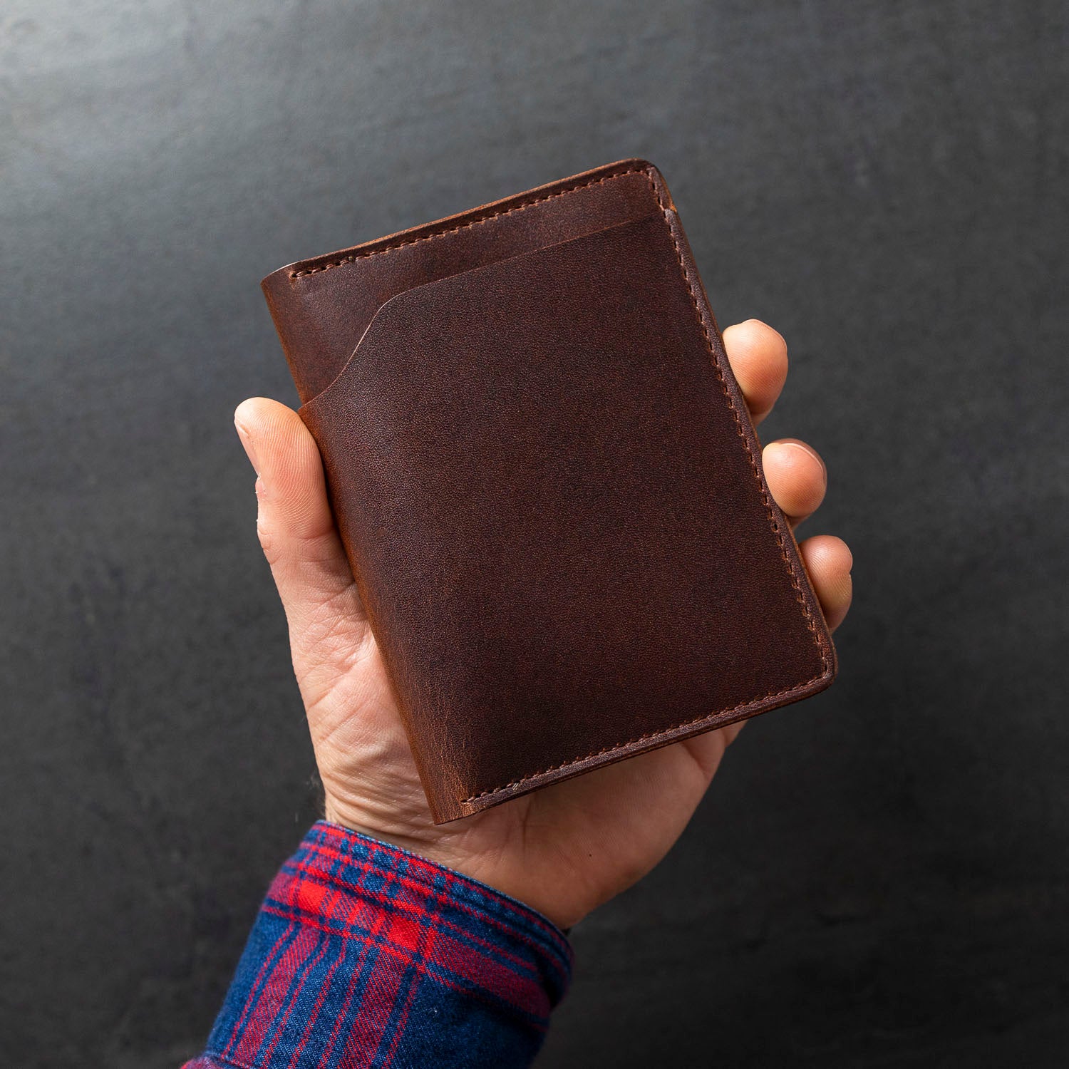 Hand showing grain luster of Cypress Fat Herbie men's wallet