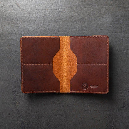 A brown leather bifold wallet, partially opened, showing the interior with card slots and a bill compartment.