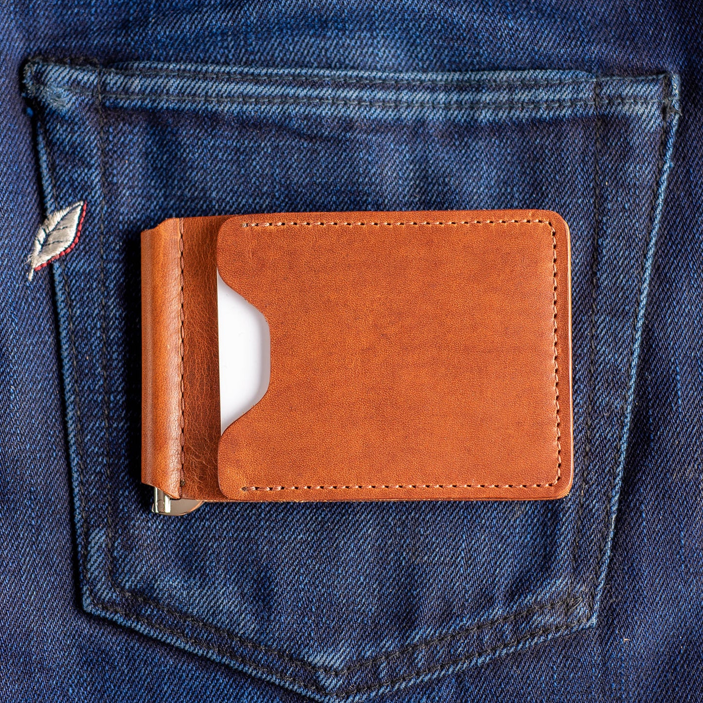 A Capone Money clip sitting on selvedge jeans with a white credit card visible