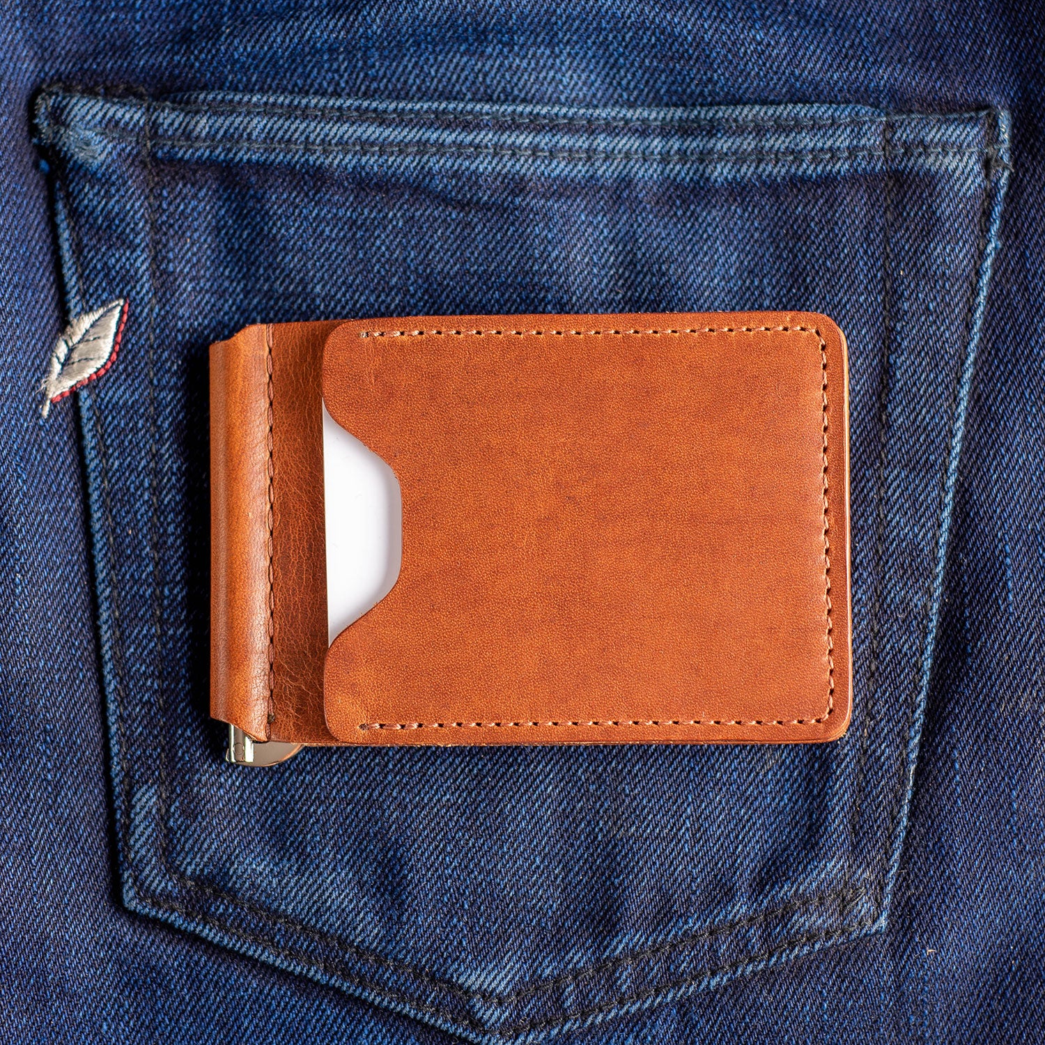 A Capone Money clip sitting on selvedge jeans with a white credit card visible