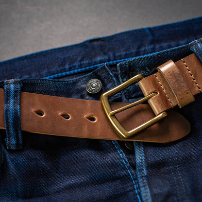 CXL natural leather men's belt shown with brass buckle visible paired with selvedge denim