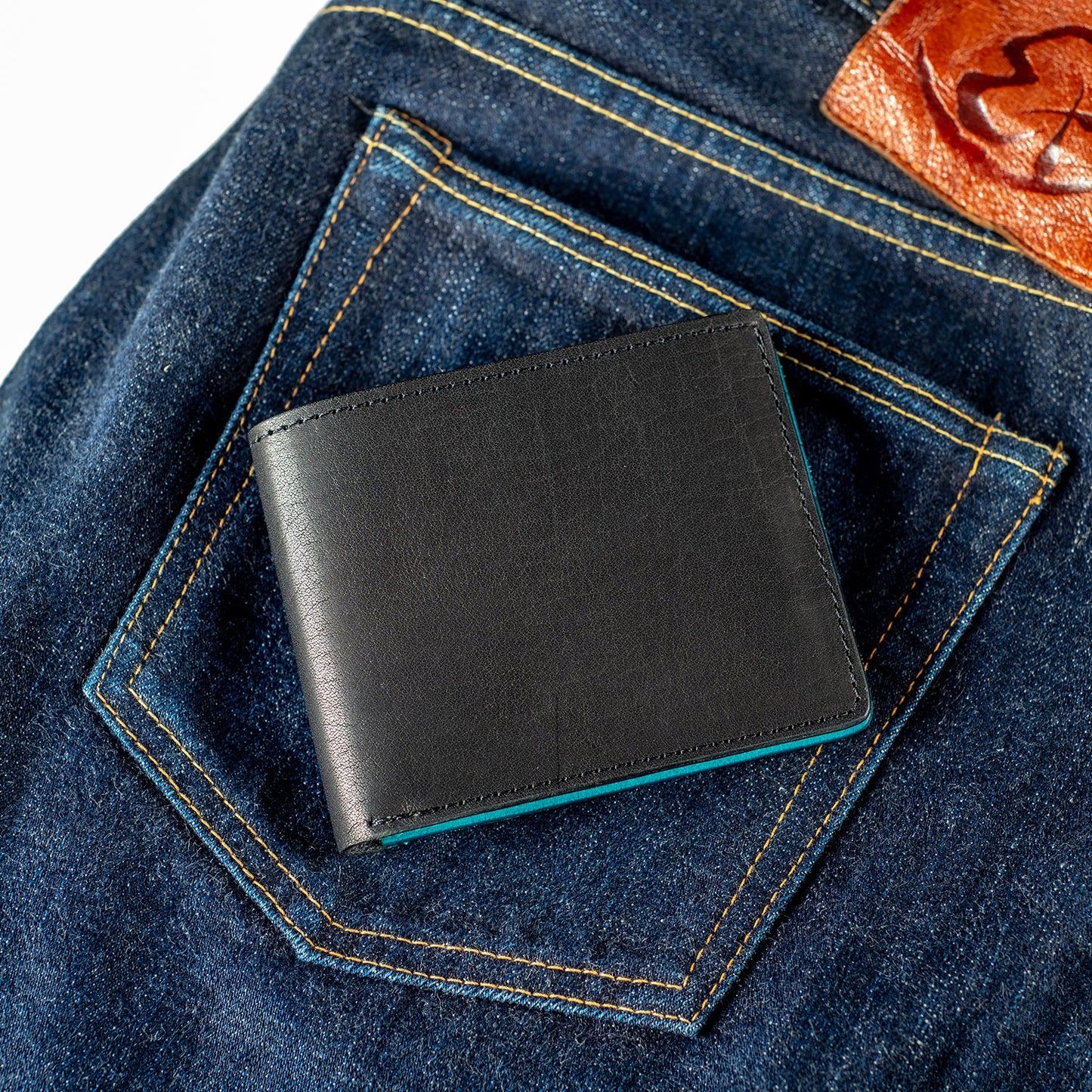 johnny the fox wallet in black and teal on jeans